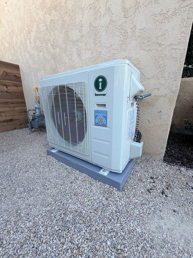 Ductless mini split outdoor condenser installed on a pad beside a San Diego home